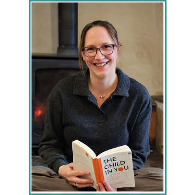 Ines smiling with book the Child in you open at a page